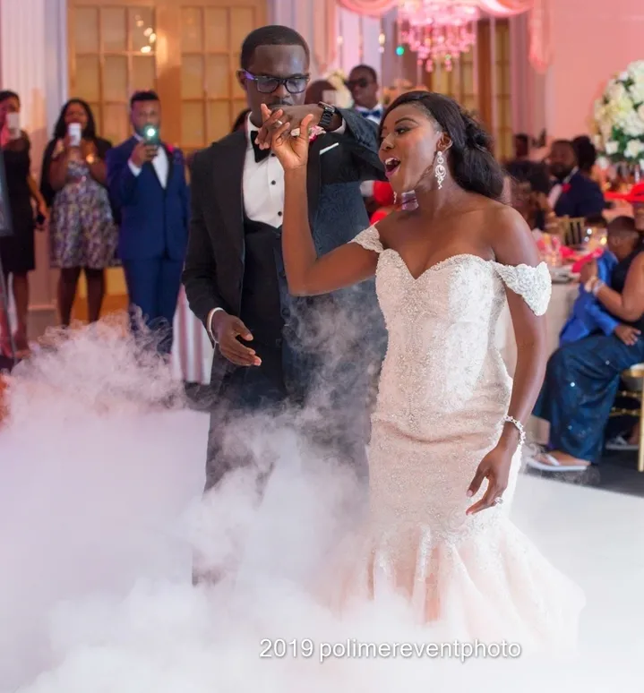 A couple is dancing in the middle of a room.