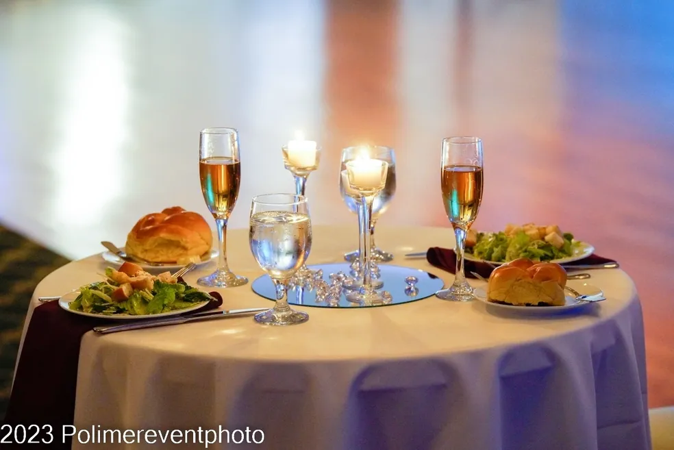 A table set with wine glasses and food.